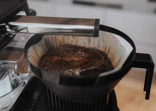 Close up of a Moccamaster brew basket with white paper filter.