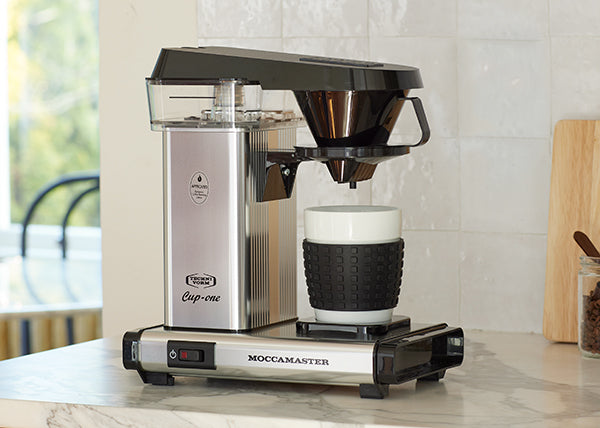 Polished silver Cup-One coffee brewer on a kitchen counter.
