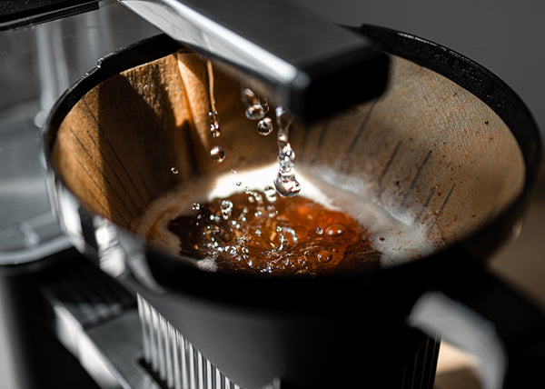 Close up of water flowing into a Moccamaster brew basket.