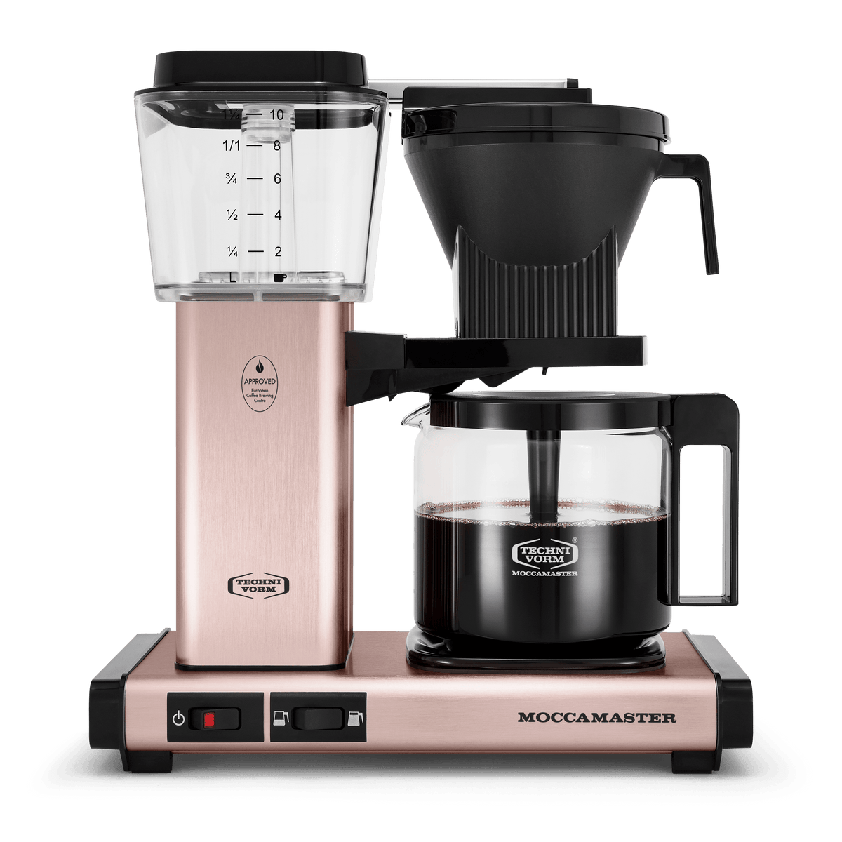 Front shot showing Moccamaster KBGV Select in Rose Gold, with rectangular tower and base, clear acrylic water reservoir with fill level marks, power and volume selector switch, glass carafe with black handle, and black automatic brew basket.