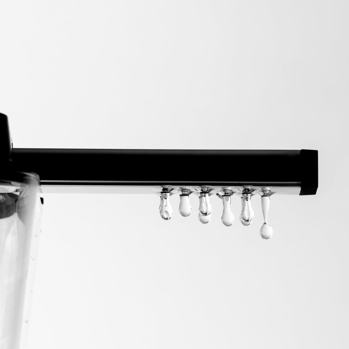 A close up of water dripping from the holes of a 9-hole outlet arm.