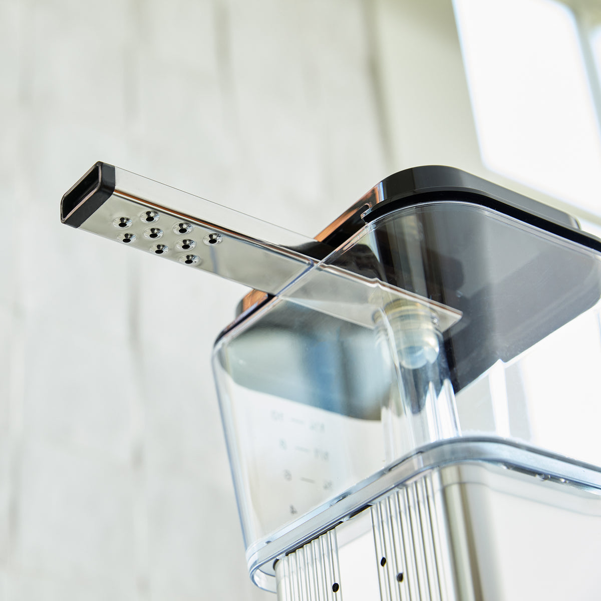 A view of the underside of a 9-hole outlet arm on a Moccamaster coffee brewer.