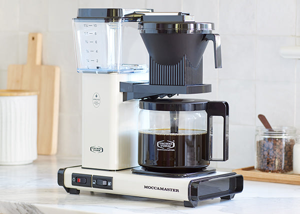 Off-White KBGV Select glass carafe coffee brewer on a kitchen counter.