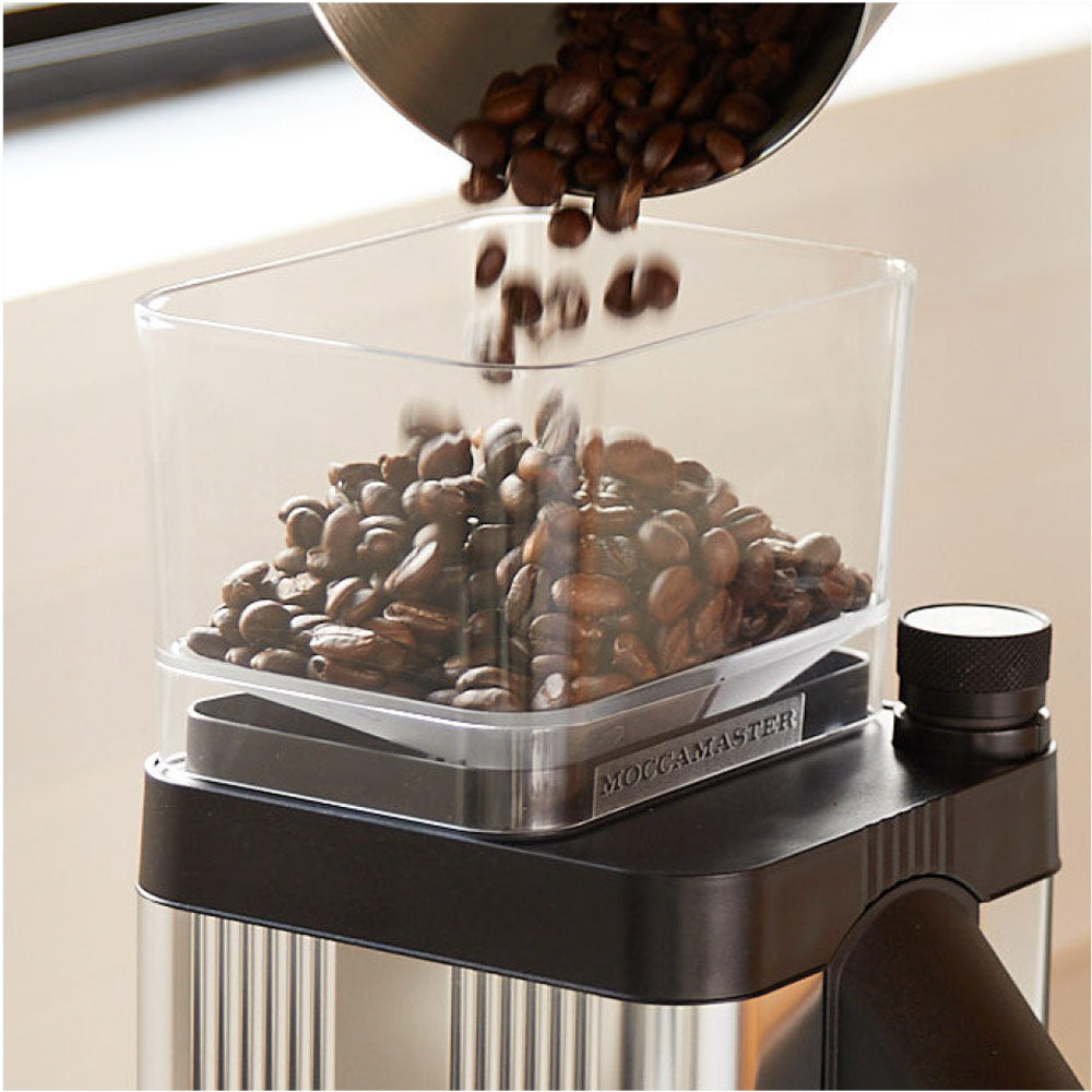 Pouring coffee beans into coffee grinder