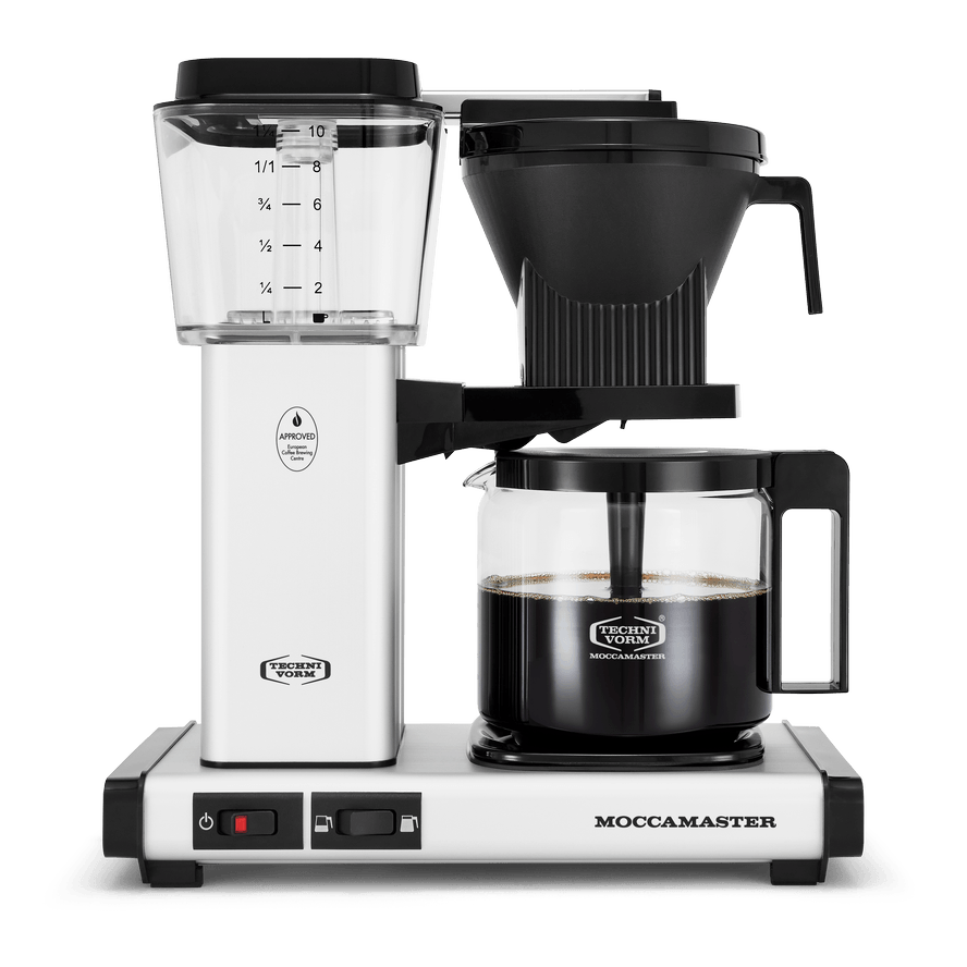 Front shot showing Moccamaster KBGV Select in Off White, with rectangular tower and base, clear acrylic water reservoir with fill level marks, power and volume selector switch, glass carafe with black handle, and black automatic brew basket.