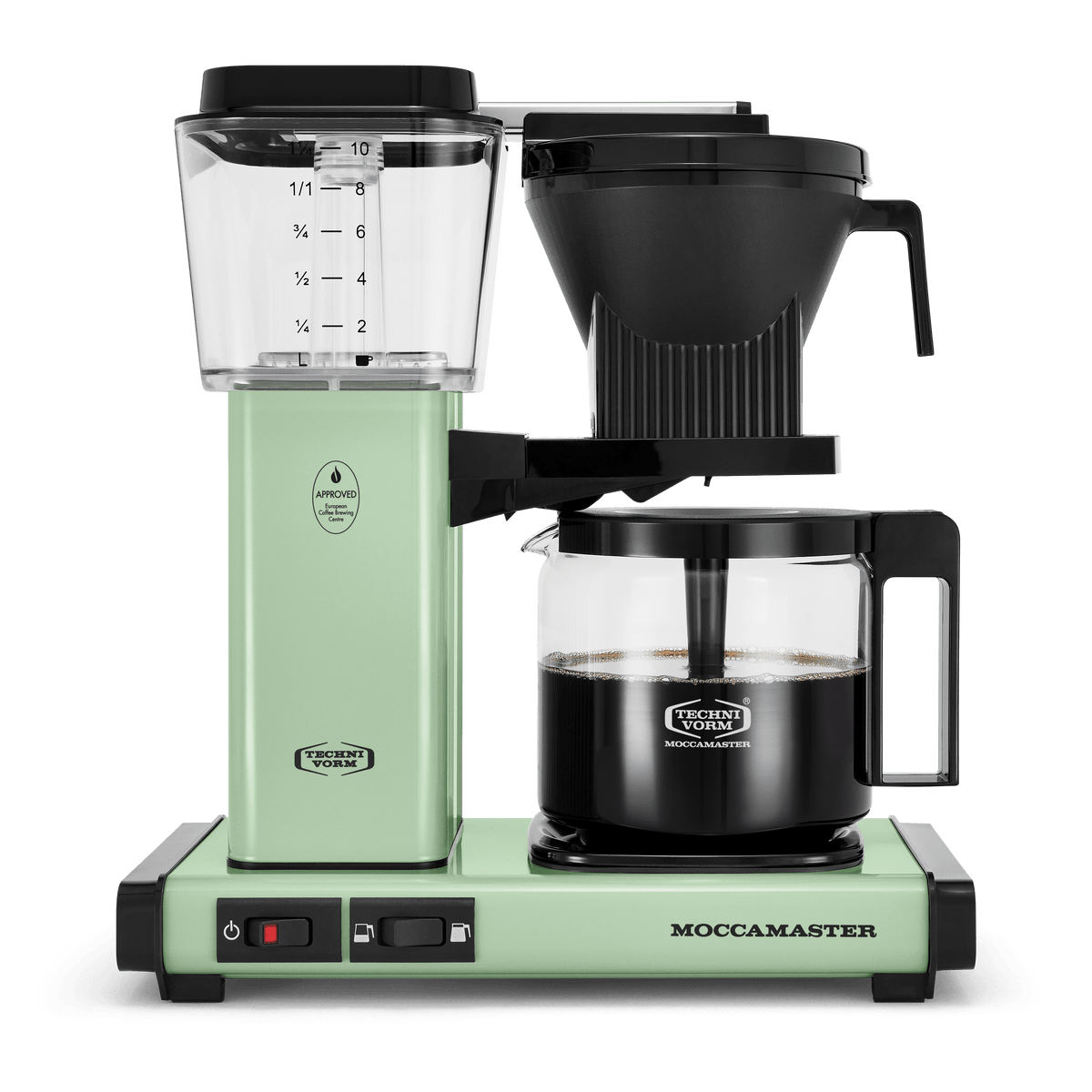 Front shot showing Moccamaster KBGV Select in Pistachio, with rectangular tower and base, clear acrylic water reservoir with fill level marks, power and volume selector switch, glass carafe with black handle, and black automatic brew basket.