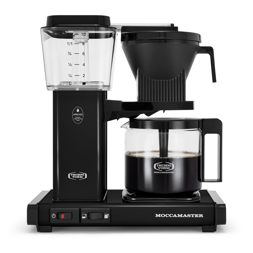 Front shot showing Moccamaster KBGV Select in Black, with rectangular tower and base, clear acrylic water reservoir with fill level marks, power and volume selector switch, glass carafe with black handle, and black automatic brew basket.